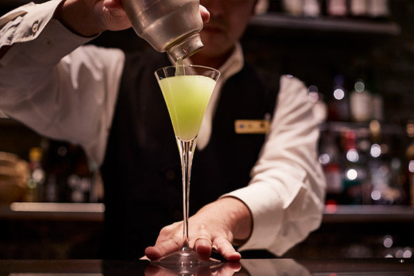 bartender pouring cocktail to the glass