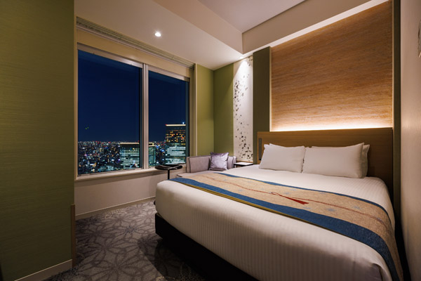 QUEEN SUPERIOR 20sqm room with bed, desk and chairs including a view of outside at night