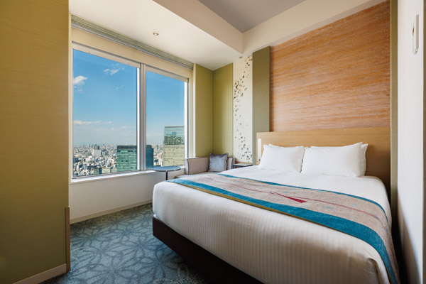 QUEEN SUPERIOR 20sqm room with bed, desk and chairs including a view of outside at daytime
