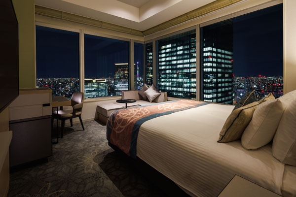 KING CORNER 22sqm room with bed, desk and chairs including a view of outside at night
