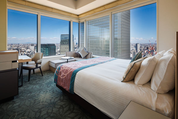 KING CORNER 22sqm room with bed, desk and chairs including a view of outside city at daytime