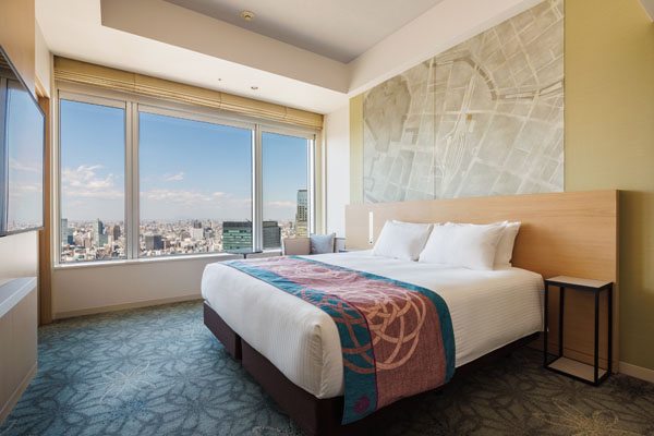 KING DELUXE 28sqm room with bed, desk and chairs including a view of outside at night