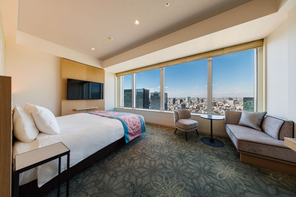 KING DELUXE 28sqm room with bed, desk and chairs including a view of outside at night