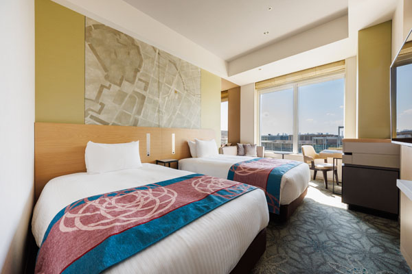 TWIN 25sqm room with 2 beds, desk and chairs including a view of outside at daytime