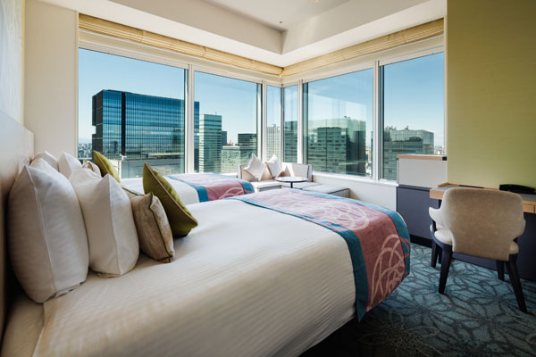 EXECUTIVE CORNER TWIN 30sqm room with 2 beds, desk and chairs on the corner including a view of outside at daytime